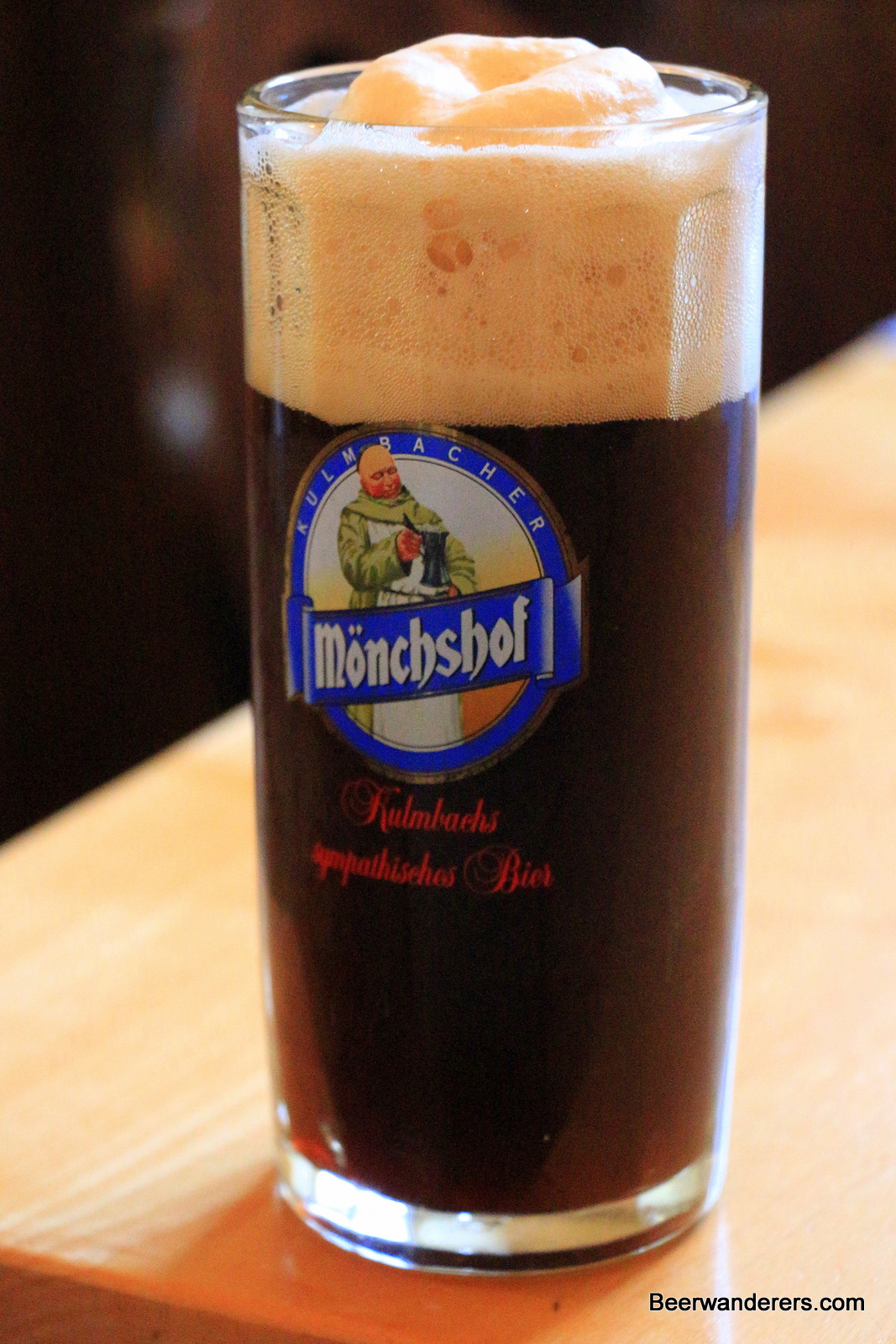 black beer with big tan head in mug