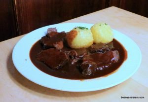 meat in dark sauce with dumplings
