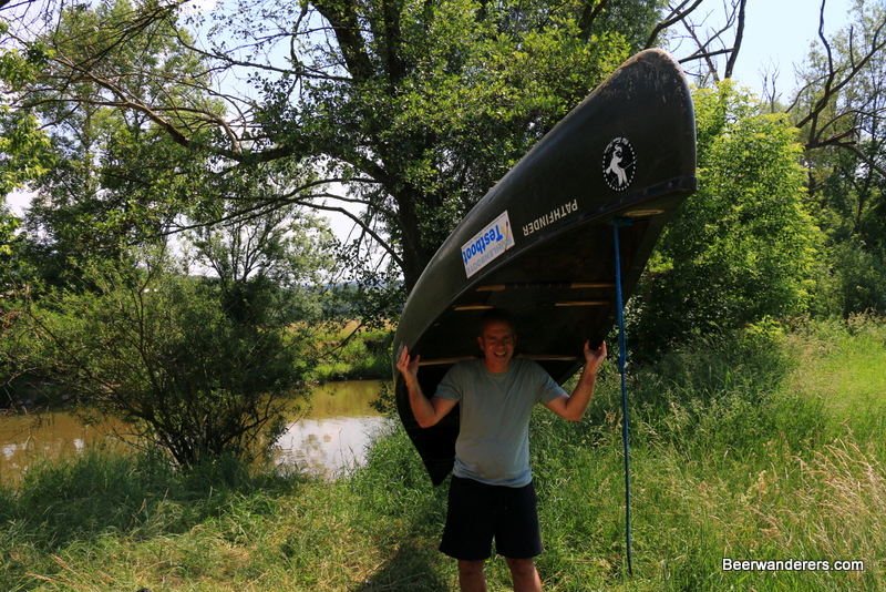 man carrying canoe on shoulders