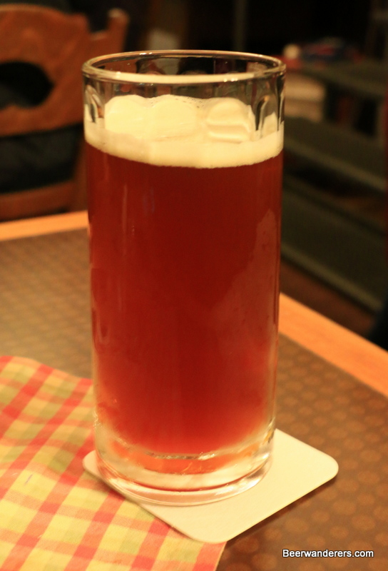 unfiltered dark amber beer in mug