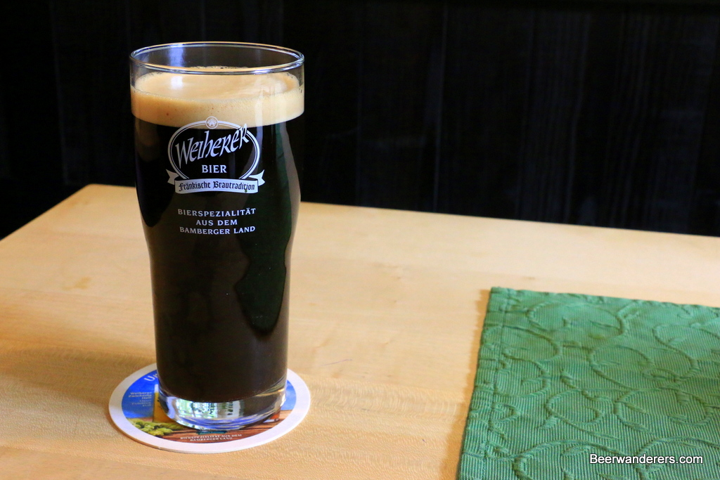 black beer in glass with tan head