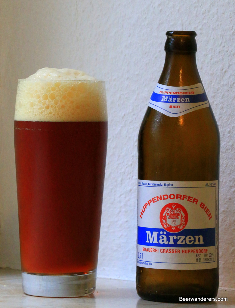 amber beer in glass with bottle