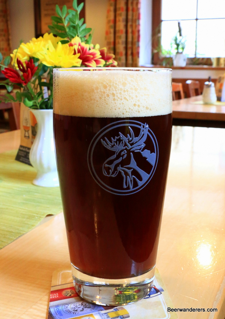 dark beer in glass with moose logo