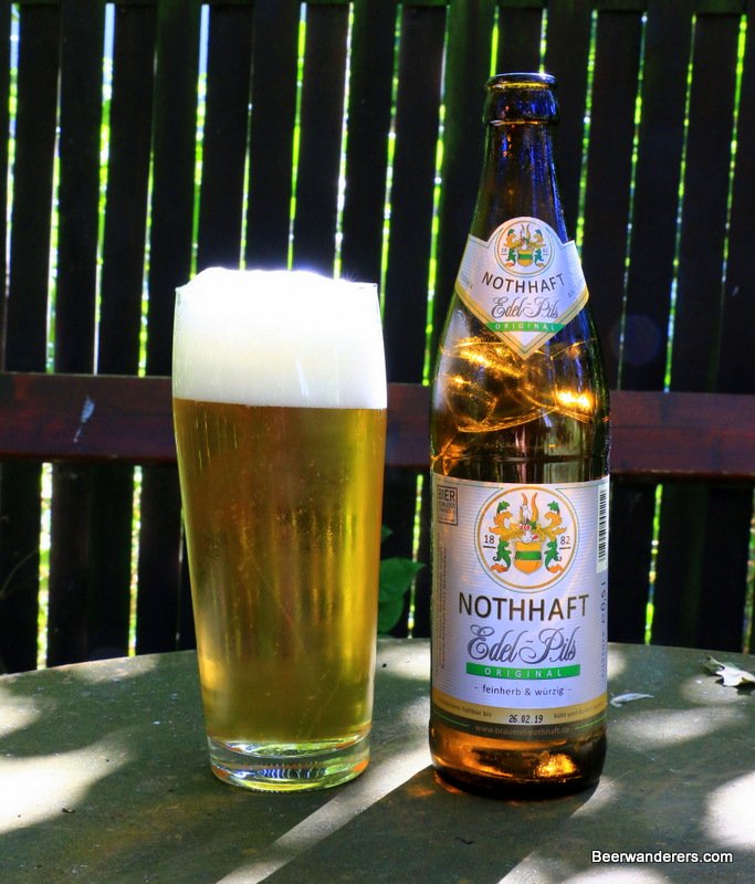 yellow beer in glass with bottle