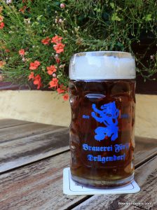 unfiltered dark beer in mug with logo