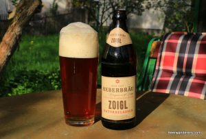 unfiltered amber beer in glass with bottle