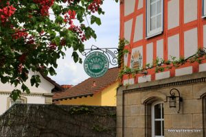 brewery sign on half-timbered building with red chestnut blooms