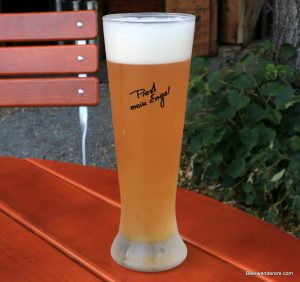 unfiltered golden beer in tall logo glass