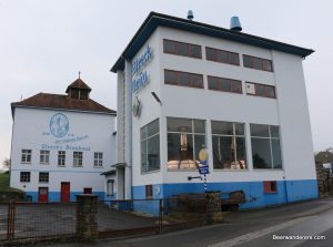 brewery exterior with copper kettles through windows