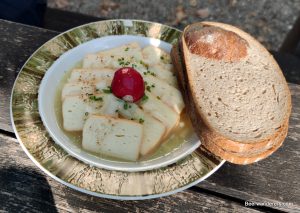limburger on plate with vinegar and onions with bread