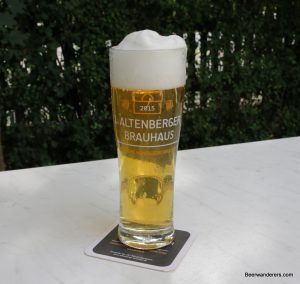 golden beer with huge head in logo glass
