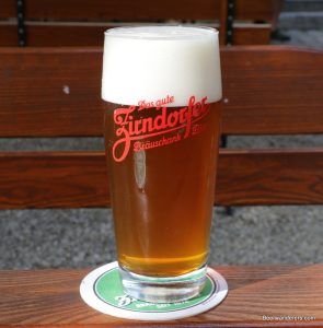 unfiltered amber beer in logo glass