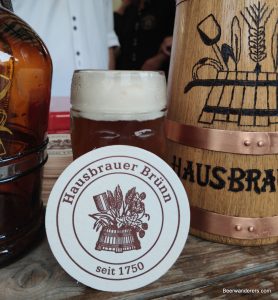 unfiltered amber beer with beer coaster and growler
