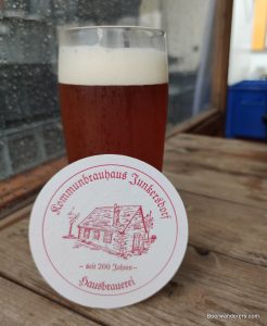 unfiltered amber beer in glass with coaster